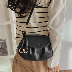 Detail view of black pleated PU leather crossbody bag featuring gold ring hardware and engraving