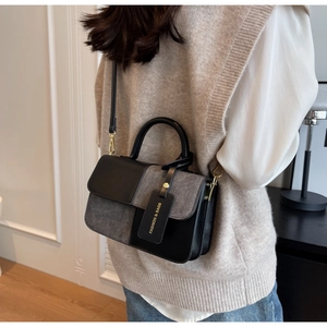 Close-up of color-block tote bag with FASHION & BAGS tag on a model's outfit