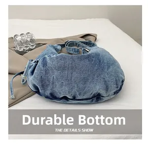 Detail des verschleißfesten Bodens dieser stilvollen blauen Denim-Umhängetasche