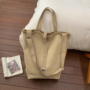 Détail du sac seau en toile avec sangle à boucle métallique et poignée supérieure