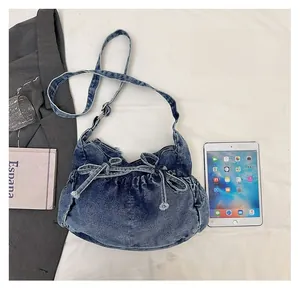 Detail of blue denim bucket bag featuring a decorative bow and pleated texture design
