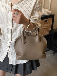 Coffee brown pebbled leather shell handbag with double handles in a casual street style