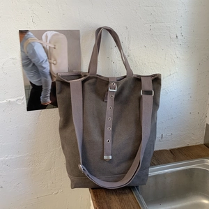 Détail du sac cabas en toile marron foncé avec bandoulière réglable et ferrures métalliques