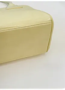 Detail of the widened reinforced bottom base on a light yellow leather shoulder bag