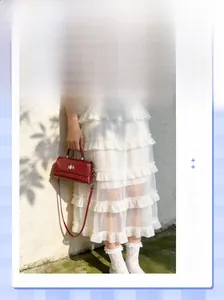 Detail of red wax leather handbag with silver twist lock on a white lace dress