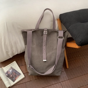Détail du sac seau en toile grise avec sangle à œillets et double poignée pratique