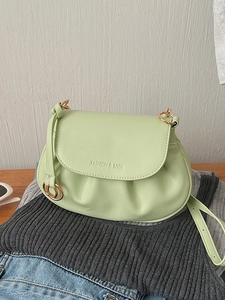 Mint green pleated crossbody bag with a magnetic flap and fashion-themed embossing