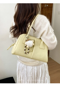 Detailed back view of a minimalist cream tote bag with festive Santa plush pendant