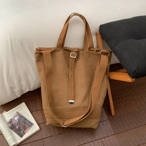 Détail d'un sac cabas en toile marron avec boucles en métal argenté et double sangle