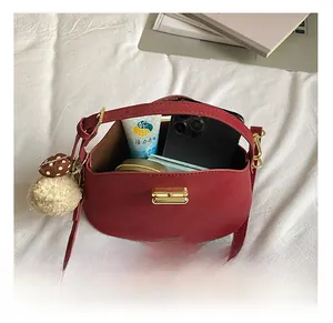 Internal view of a red crescent bag showing storage for phone, cream and makeup