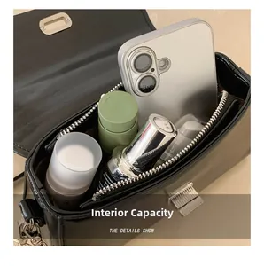 Internal view of black leather handbag showing storage space for phone and cosmetics