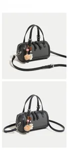 Detail of Boston handbag in grey fabric and black leather with cute bear charm