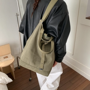 Détail du sac seau en toile vert armée avec bandoulière large et œillets métalliques