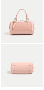 Pink cylinder handbag with textured fabric panel and protective metal feet on base