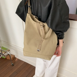 Détail du sac cabas en toile kaki avec bandoulière réglable et œillets métalliques