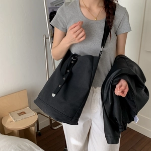 Vue détaillée du grand sac seau en toile noire avec œillets métalliques argentés