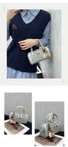 Silver bowling bag with woven texture, dual handles, and a cute white bear charm