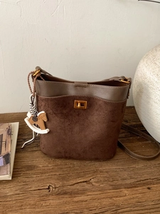Chic dark brown patchwork bucket bag with vintage metal lock and horse charm