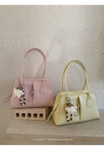 Detail of minimalist retro tote bags in pink and yellow with cute pom-pom pendants