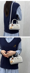 Mini grey mesh Boston bag with plush bear charm and crossbody strap on model