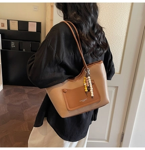 Dettaglio della borsa tote vintage in pelle testurizzata con ciondolo in perline di legno