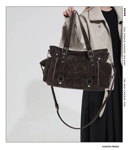 Detail of dark brown vintage tote bag with retro leather texture and adjustable shoulder strap