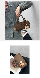 Detail view of brown Boston bag with cute bear charm and plush ball accessories