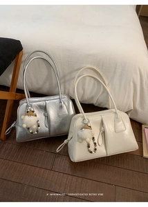Close-up of minimalist retro tote bags in silver and beige with plush doll charms