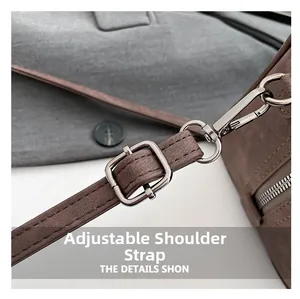 Detail view of adjustable brown suede shoulder strap with silver metal buckle and clasp