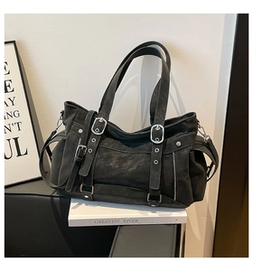 Detailed close-up of a black motor tote bag with metal buckles and rivet decorations