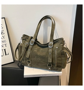 Detail of vintage olive green tote bag with multi-pockets and metal buckle straps