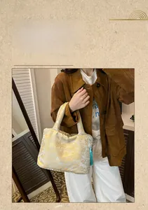 Détail du sac cabas en jacquard de style chinois avec broderie dorée et gland bleu ciel