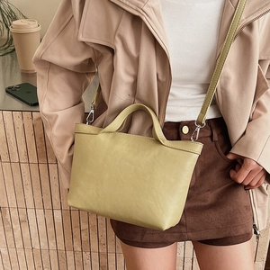 Detailed lime green tote bag showing pebbled leather texture and detachable metal strap