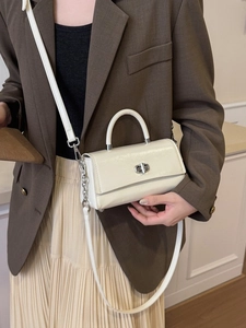 Chic cream-white crossbody bag with silver twist lock and handle shown on a model
