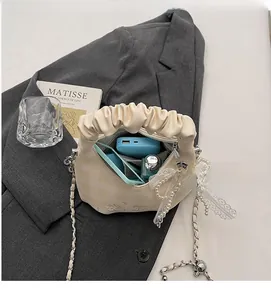 Interior view of pleated cream bag showing storage capacity for phone and essentials
