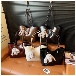 Cinq sacs fourre-tout minimalistes de couleurs variées sur canapé avec breloques lapin