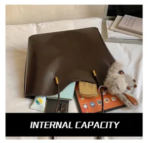 Détail d'un sac cabas marron foncé montrant sa grande capacité pour laptop et tablette