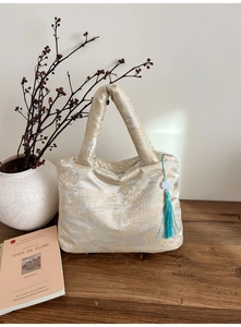 Détail du sac cabas en satin brodé avec motifs chinois traditionnels et pompon bleu décoratif
