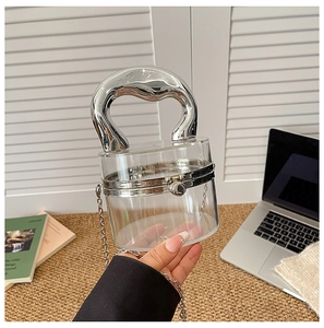 Macro view of clear acrylic cylindrical bag with bold silver liquid metal handle
