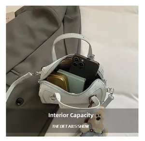 Internal view of a light blue matte leather crossbody bag showing capacity and striped lining