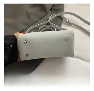 Detail view of the light blue handbag base featuring four protective metal studs and leather