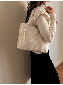 Détails d'un sac bandoulière en soie jacquard avec bandoulière douce et pompon