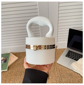 Close-up of white cylindrical clutch bag with gold metal clasp and luxury chain strap