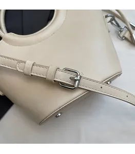 Détail d'une bandoulière réglable en similicuir avec boucle et rivets en métal argenté