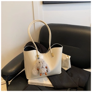 Détail du grand sac cabas en similicuir beige avec un lapin en peluche gris décoratif