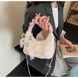 Detail of pleated handle bag with bear embroidery and pearl lace bow charm