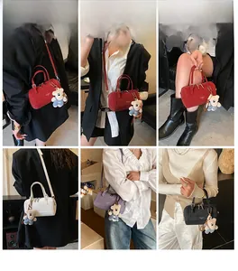 Detail view of stylish Boston bag set in four colors with bear charm and crossbody strap