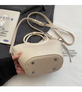 Détails du fond du sac seau crème avec rivets anti-usure argentés et texture cuir premium