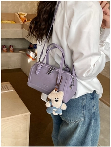 Close-up of light purple Boston bag with cute plush bear charm in a lifestyle setting