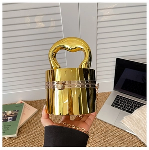 Detail of creative gold barrel-shaped evening bag with a shiny metallic mirror finish